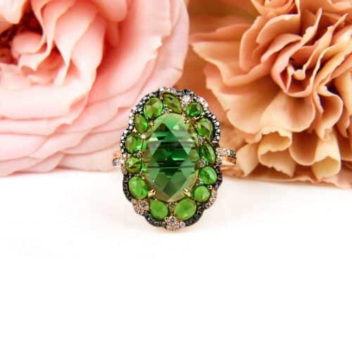 Ring in roos goud gezet met groene saffier, zwarte en witte diamant